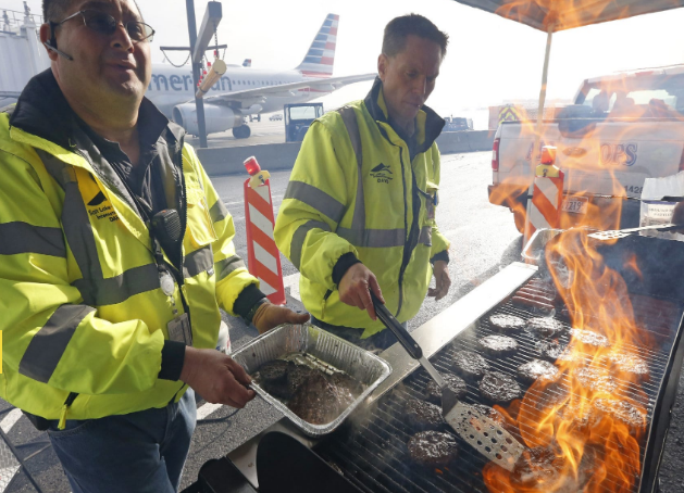 Các nhân viên sân bay nướng thịt ngay tại sân bay Salt Lake City ở Salt Lake City ngày 16/1/2019. Được biết, giới chức sân bay Salt Lake City đã cung cấp bữa trưa barbecue miễn phí cho các nhân viên TSA, FAA và lực lượng Bảo vệ Biên phòng và Hải quan Mỹ để giúp họ giữ vững tinh thần trong thời kỳ khó khăn này. Ảnh: AP.
