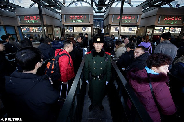 Các hành khách vào ga tàu ở Bắc Kinh trong hành trình về quê ăn Tết năm 2019. Ảnh: Reuters.