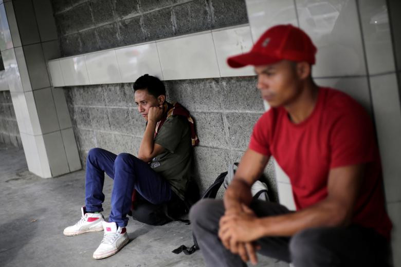 Hai thanh niên Honduras ngồi chờ tại một bến xe ở San Pedro Sula.