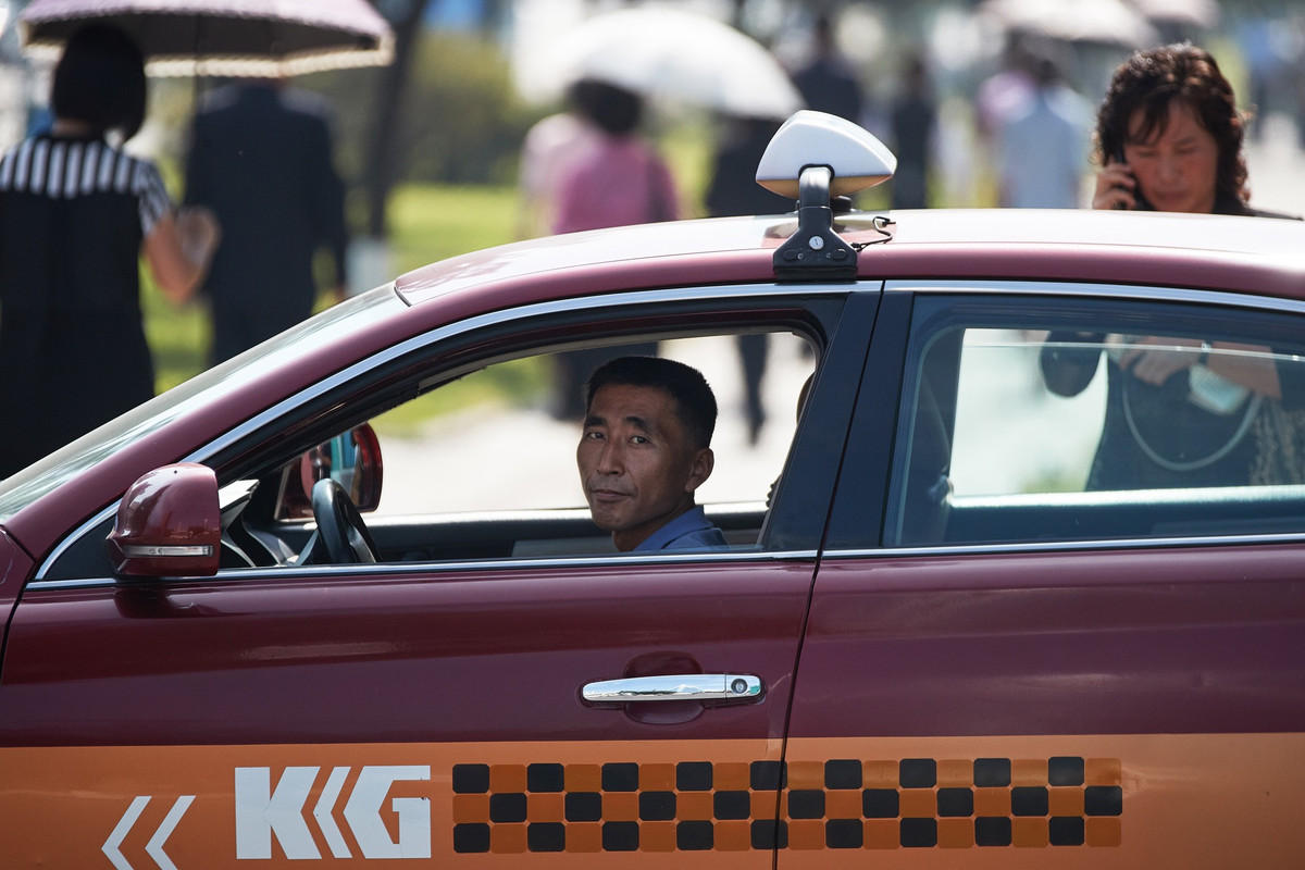 Người đàn ông lái taxi trên đường phố.