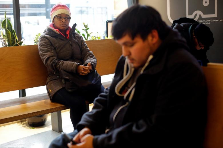 Ebony Grays (trái) và John Salinas, nhân viên TSA, ngồi chờ đến lượt vào nhận đồ ăn tại Lakeview Pantry ngày 14/1.