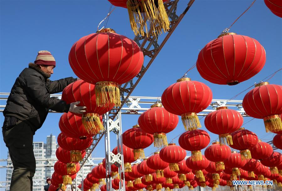 Người đàn ông sắp xếp những chiếc đèn lồng đỏ trong công viên ở thành phố Binzhou, tỉnh Sơn Đông, ngày 26/1.