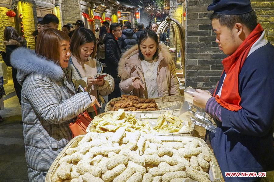 Mọi người mua những món ăn vặt truyền thống tại khu phố ẩm thực và văn hoá ở Đường Sơn ngày 26/1.