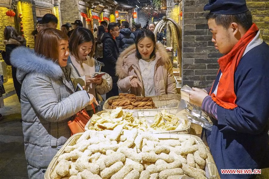 Mọi người mua những món ăn vặt truyền thống tại khu phố ẩm thực và văn hoá ở Đường Sơn ngày 26/1.