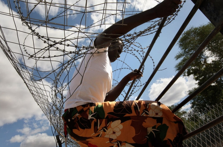 Một người nhập cư Zimbabwe trèo qua hàng rào thép gai để vượt biên bất hợp pháp vào Nam Phi. Trước những xung đột về kinh tế và chính trị trong nước, nhiều người Zimbabwe đã tìm cách vượt biên, bất chấp những cuộc tấn công bạo lực nhằm vào những người nhập cư nước ngoài ở Nam Phi.