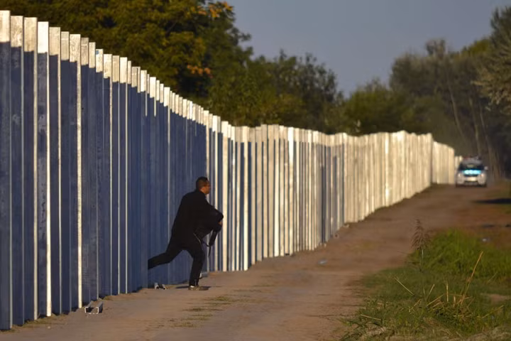 Một người di cư chạy đi sau khi vào được Hungary bằng cách vượt qua hàng rào bảo vệ tạm thời dọc biên giới Hungary và Serbia ngày 7/9/2015.