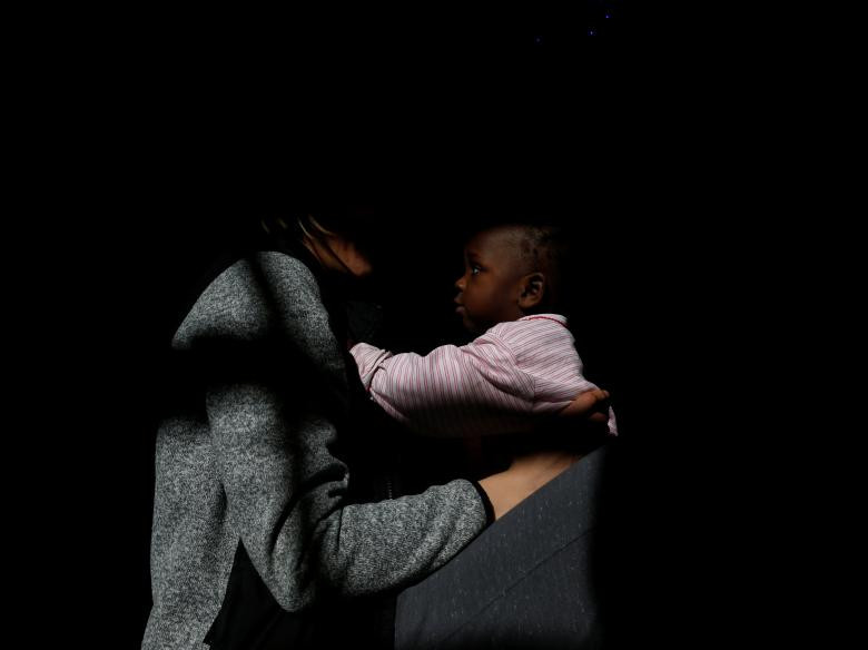 Thành viên thuỷ thủ đoàn chơi đùa với một em nhỏ di cư trên tàu cứu hộ ngày 4/1.