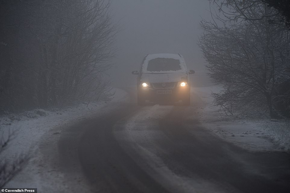 Tài xế điều khiển xe dưới trời mưa tuyết ở Manchester tối 29/1.