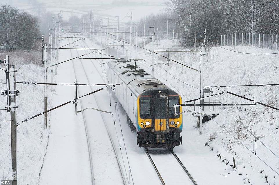 Đoàn tàu đi qua ngôi làng bị tuyết phủ trắng xoá ở Cumbria.