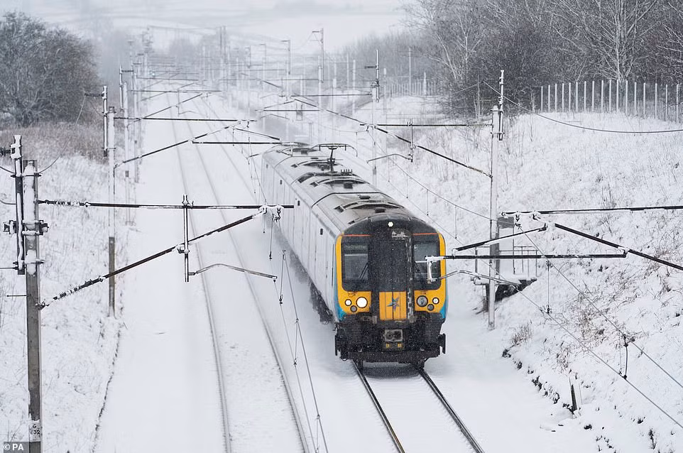 Đoàn tàu đi qua ngôi làng bị tuyết phủ trắng xoá ở Cumbria.