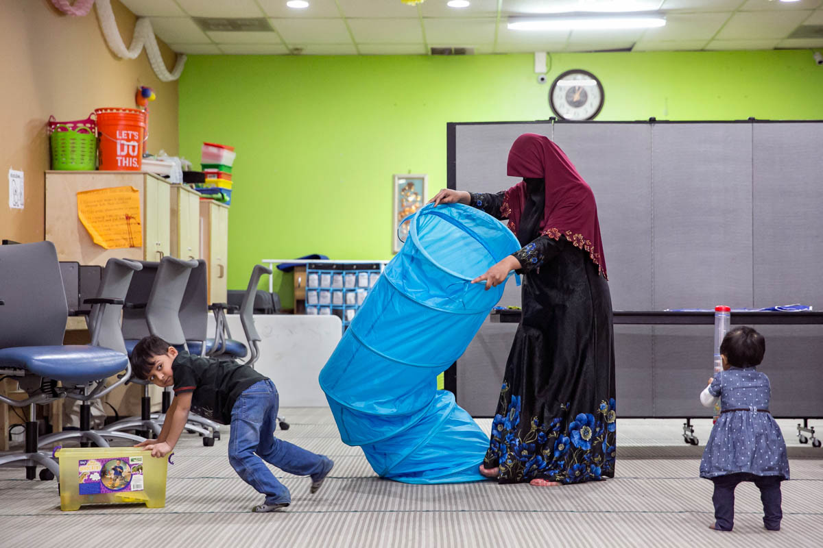 Sakinah, 23 tuổi, dọn dẹp phòng học sau khi tan học, trong khi các con của cô là Shafi Rukh (4 tuổi) và Nur Sharifah (1 tuổi) chơi đùa.