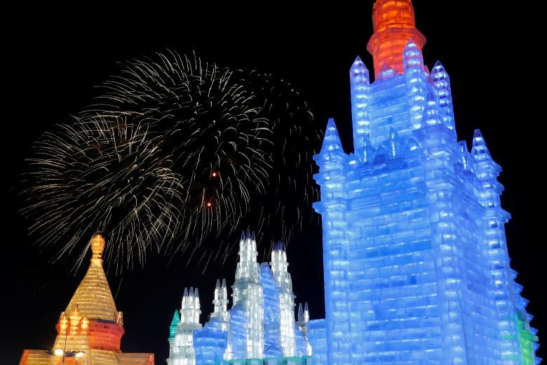 Pháo hoa thắp sáng bầu trời phía trên một những công trình điêu khắc bằng băng ở Cáp Nhĩ Tân trong hôm khai mạc lễ hội. Ảnh: Reuters.