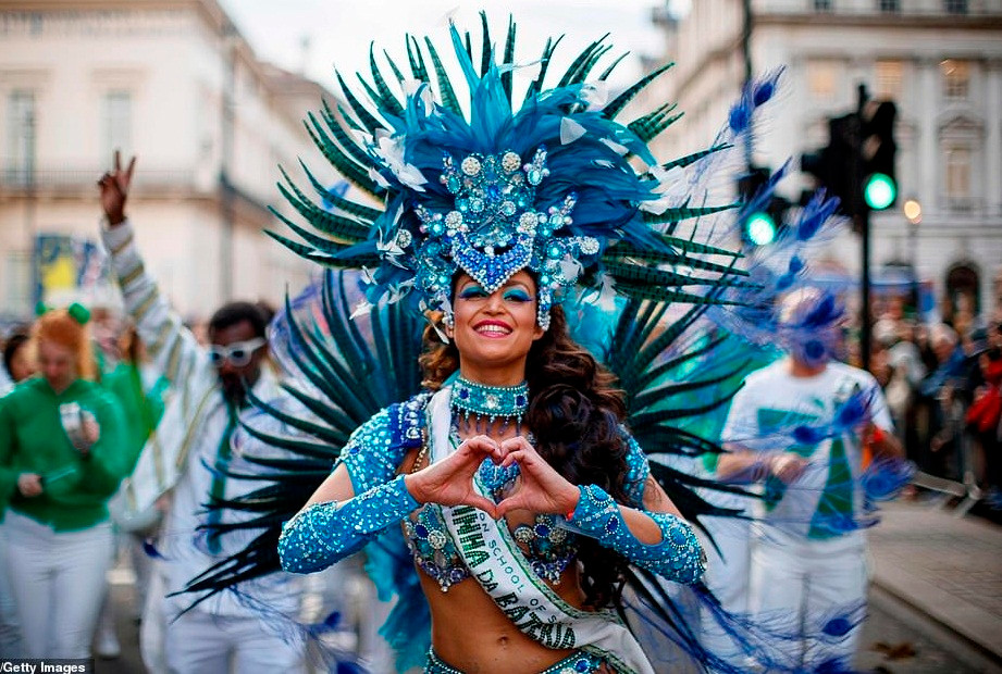 Nữ vũ công trong bộ trang phục cầu kỳ cười tươi khi tham gia buổi diễu hành mừng Năm mới 2019 ở London.