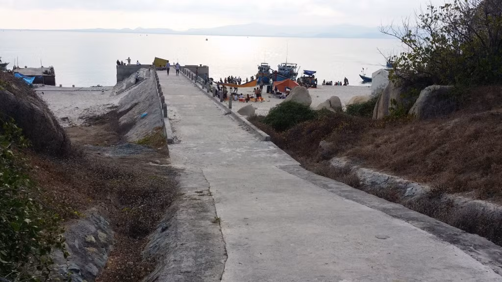 Trong ảnh là con đường bê tông duy nhất trên đảo, dẫn đến nơi ở của bộ đội biên phòng. Trước tiên, bạn phải tìm một điểm nghỉ chân, xin ở tạm, hoặc ghé quán ăn ở trên đảo. Đa số mọi người đều chuẩn bị đầy đủ vật dụng để dựng trại gần bờ biển. Vì ở đây không có dân, không có điện và thiếu nước, mọi người thường chỉ vui chơi trong ngày. Nếu muốn ở qua đêm trên đảo, bạn phải xin phép bộ đội biên phòng.