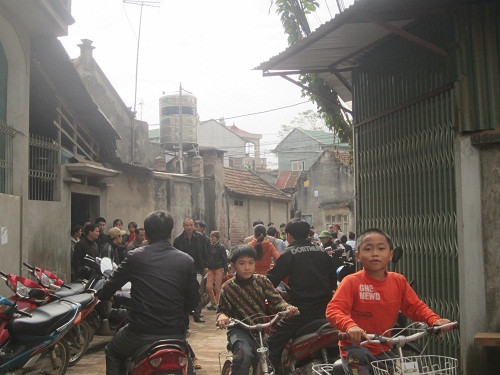 Cả ngõ nhỏ chật kín người và xe, không khí tang thương bao trùm.