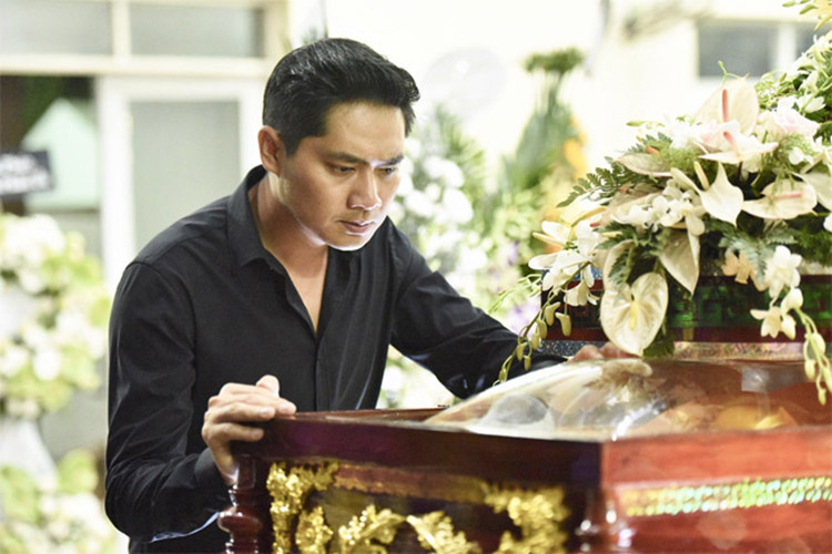 Minh Luân lặng người bên linh cữu của nghệ sĩ Lê Bình. Ảnh: Dân Việt