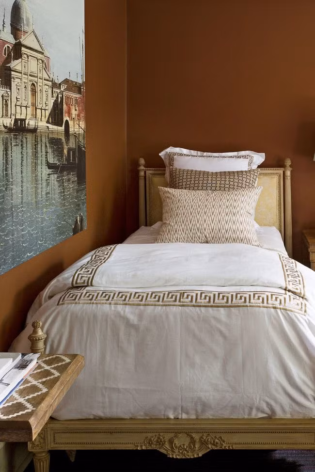 Màu đất nung: Phòng ngủ toát lên sự ấm áp với những bức tường bằng đất nung. Một tác phẩm nghệ thuật lớn nằm chính giữa căn phòng giúp phá vỡ gam màu tối. Màu nâu luôn là trải nghiệm bất ngờ cho bất cứ ai thích thử nghiệm màu sắc.