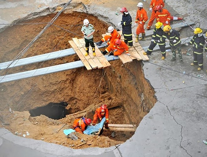 Lực lượng cứu hộ chuẩn bị di chuyển một thi thể được phát hiện dưới hố sâu trên một con đường ở Thâm Quyến, Trung Quốc. Năm người đã thiệt mạng trong vụ tai nạn này. (Ảnh: SCPM)