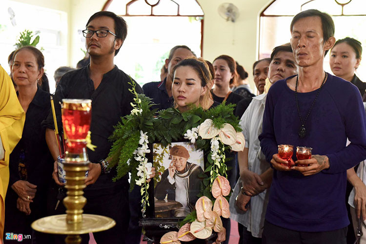 Con gái nuôi của Lê Bình ôm di ảnh bố nuôi trong lễ tang. Ảnh: Zing