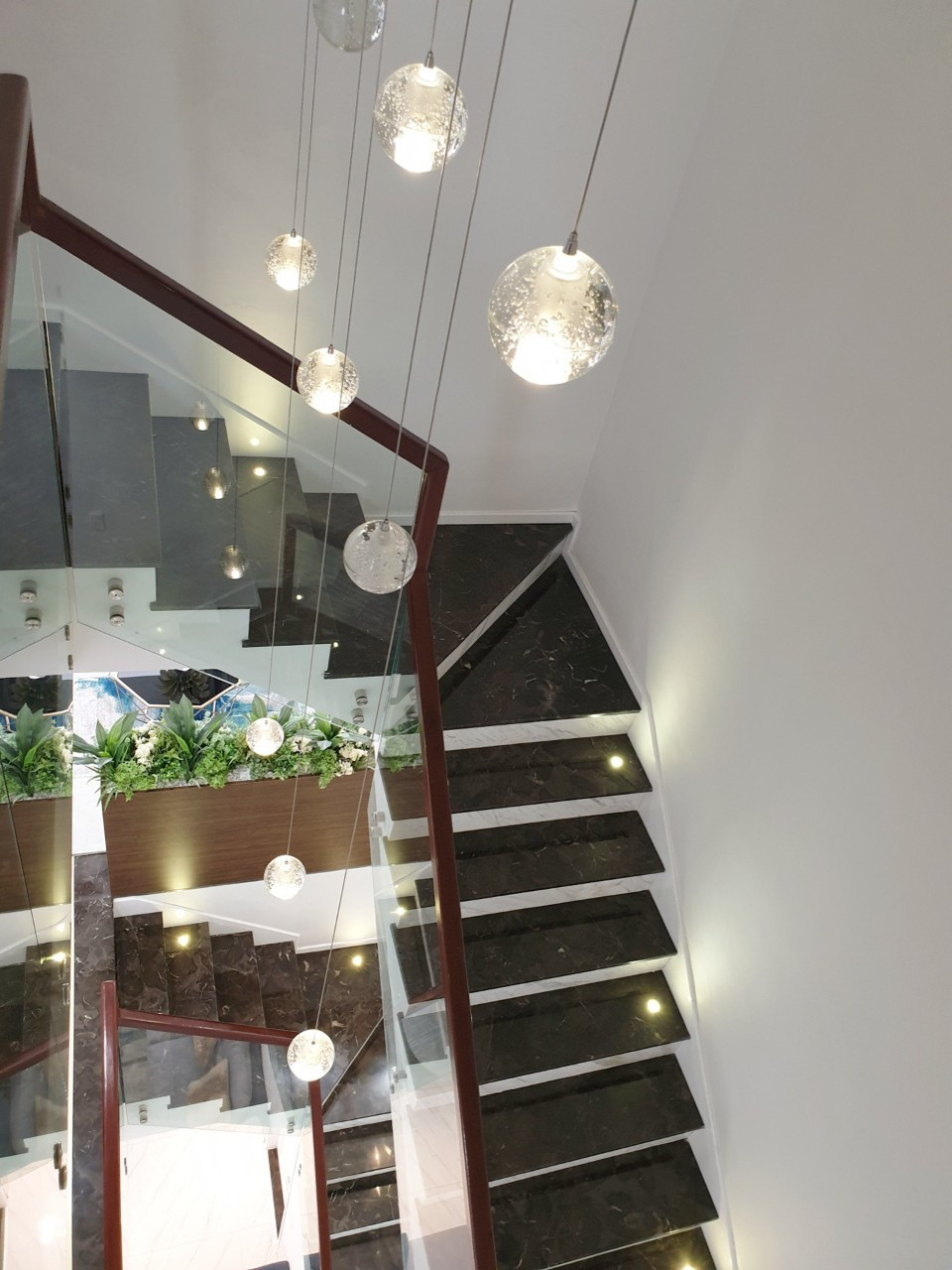 Lối lên cầu thang thiết kế đèn thả và trồng cây xanh. Ảnh: Lao động