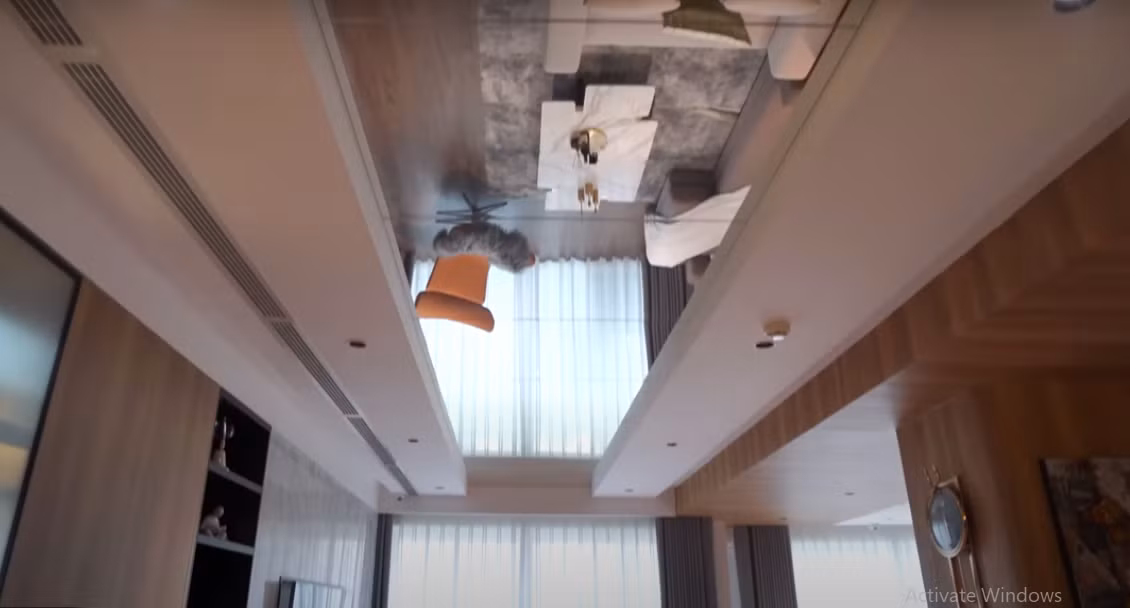 Điểm nhấn trong phòng khách là phần trần bằng gương trải dài từ cửa ra vào đến không gian bên trong, tạo cảm giác không gian rộng rãi hơn.