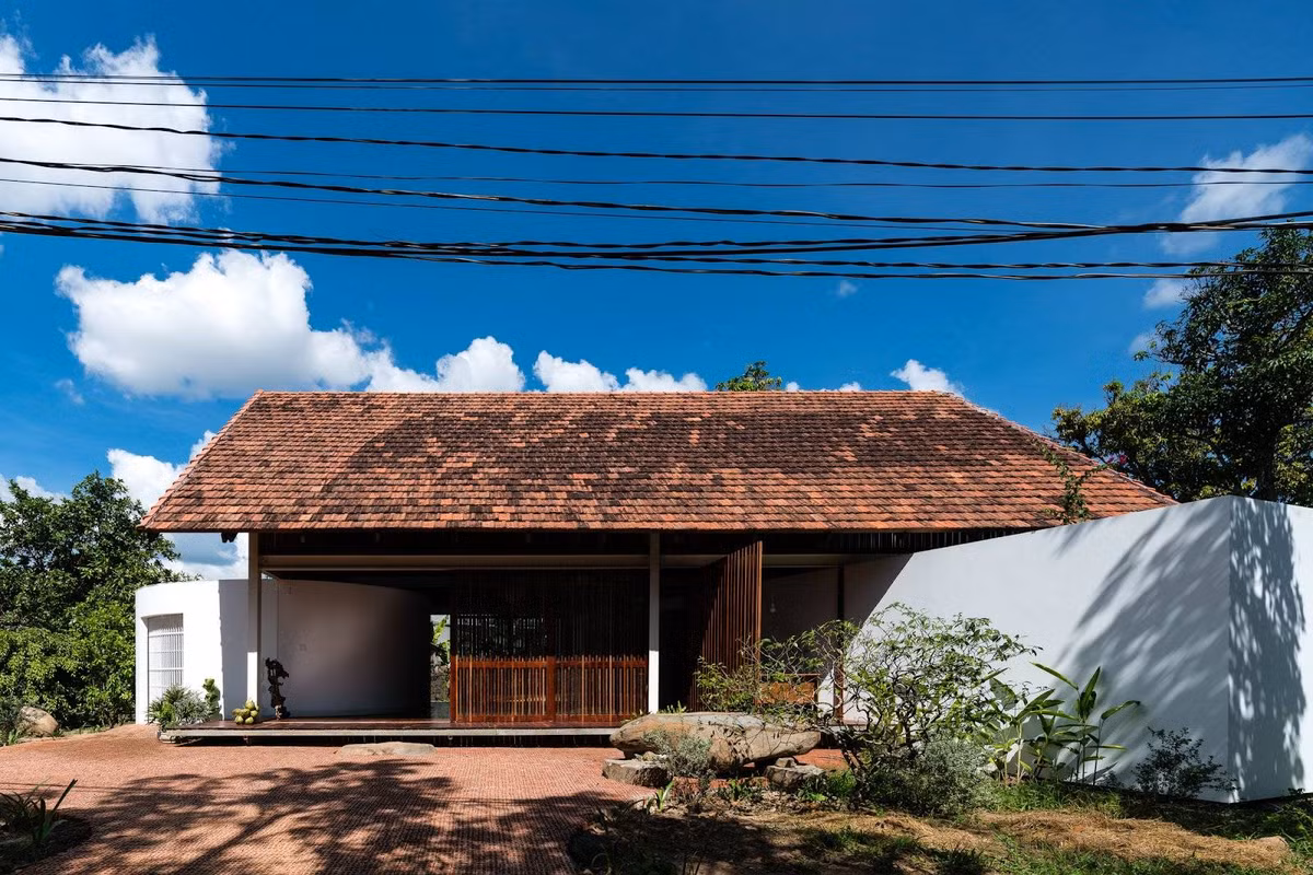 Phía trước ngôi nhà cấp 4 là sân gạch đỏ cùng một khu vườn nhỏ trồng hoa và cây cảnh.