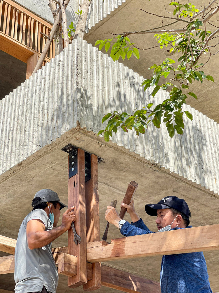 Gỗ được tái sử dụng để xây dựng mái, cầu thang, và nội thất. Nguyên vật liệu và sức lao động đều lấy từ địa phương, giúp tiết kiệm chi phí và bảo vệ môi trường.