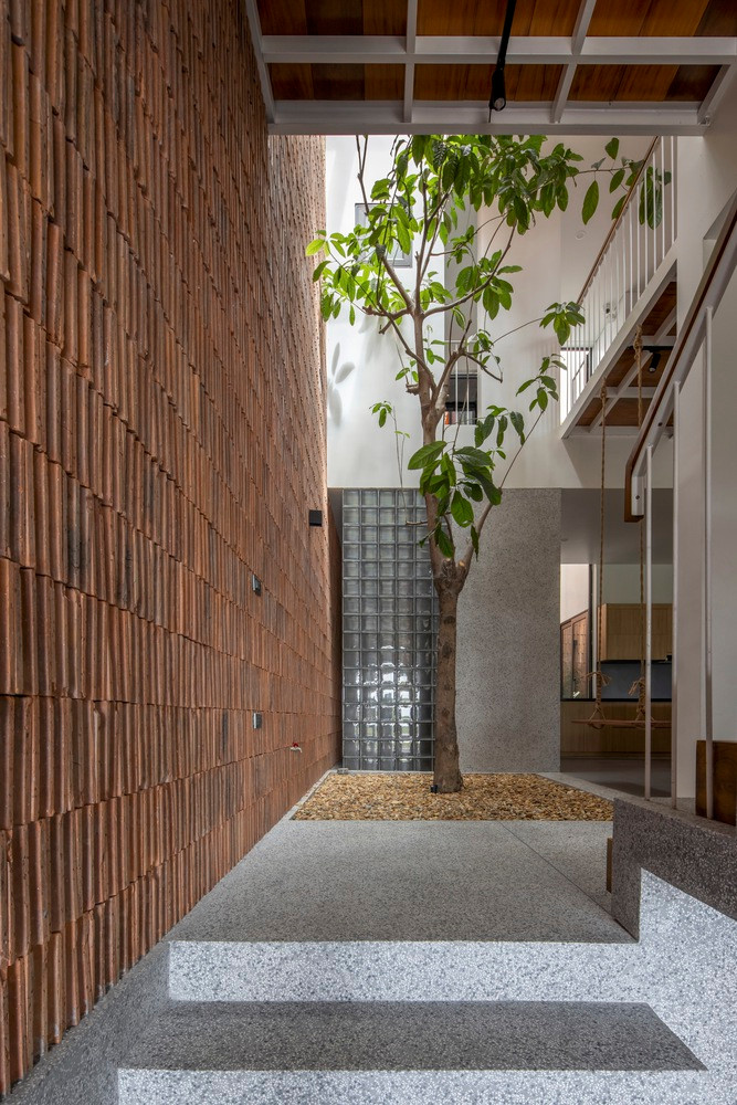 Khoảng trống dưới cầu thang được tận dụng để treo xích đu, tạo điểm nhấn thiết kế.