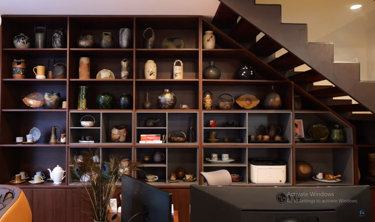 Phòng làm việc rộng rãi, được trang trí bằng một kệ tủ đự đồ gốm sứ.