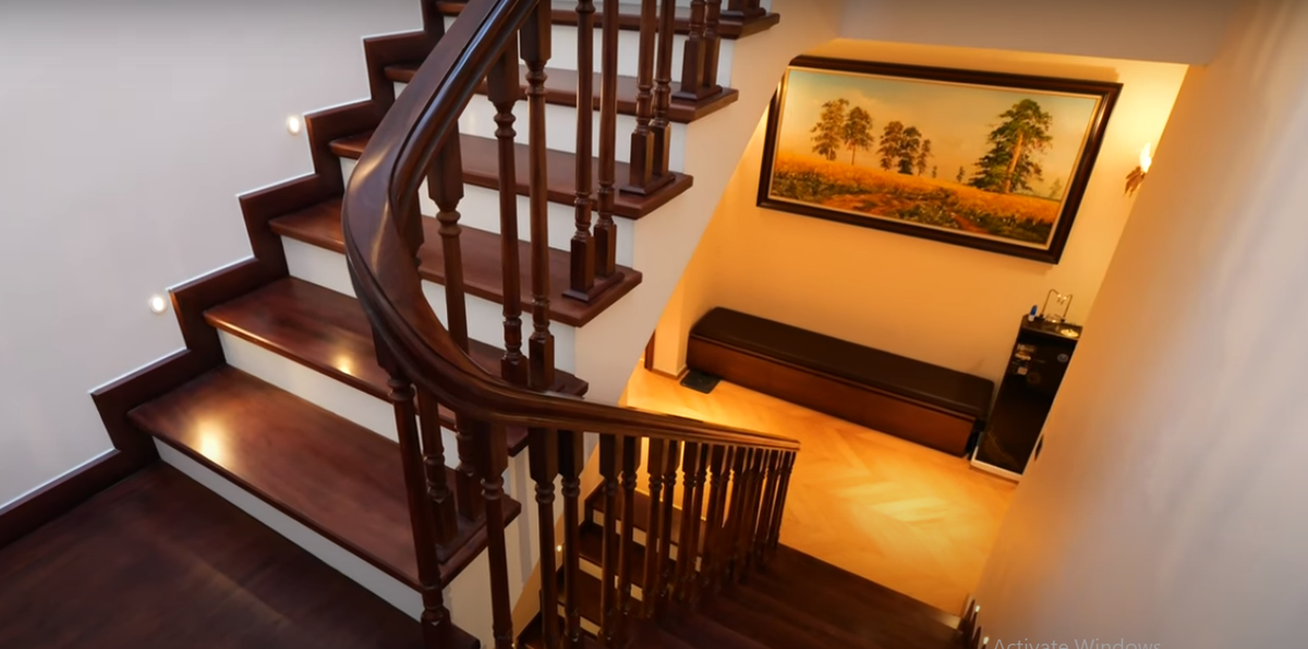 Cầu thang làm từ gỗ gõ đỏ, có đèn chiếu sáng ở mỗi bậc rất bắt mắt.