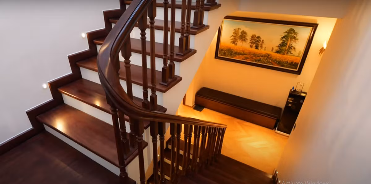 Cầu thang làm từ gỗ gõ đỏ, có đèn chiếu sáng ở mỗi bậc rất bắt mắt.