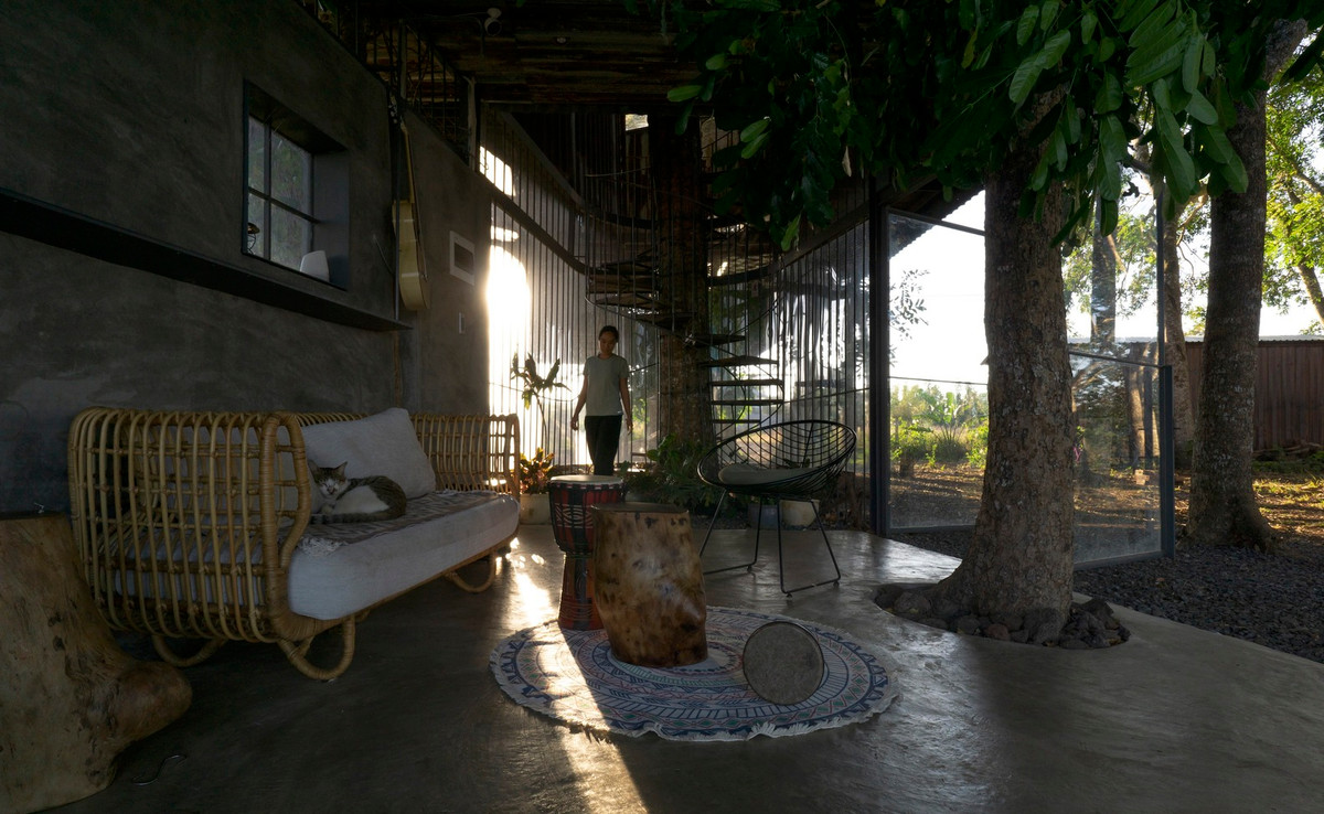 Tại tầng 1, không gian phòng khách chỉ một khu vực nhỏ được bao che bơi hệ cửa. Tất cả không gian còn lại phủ nhẹ 1 lớp đá 1x2 để ít tác động nhất đến cảnh quan khu rừng.