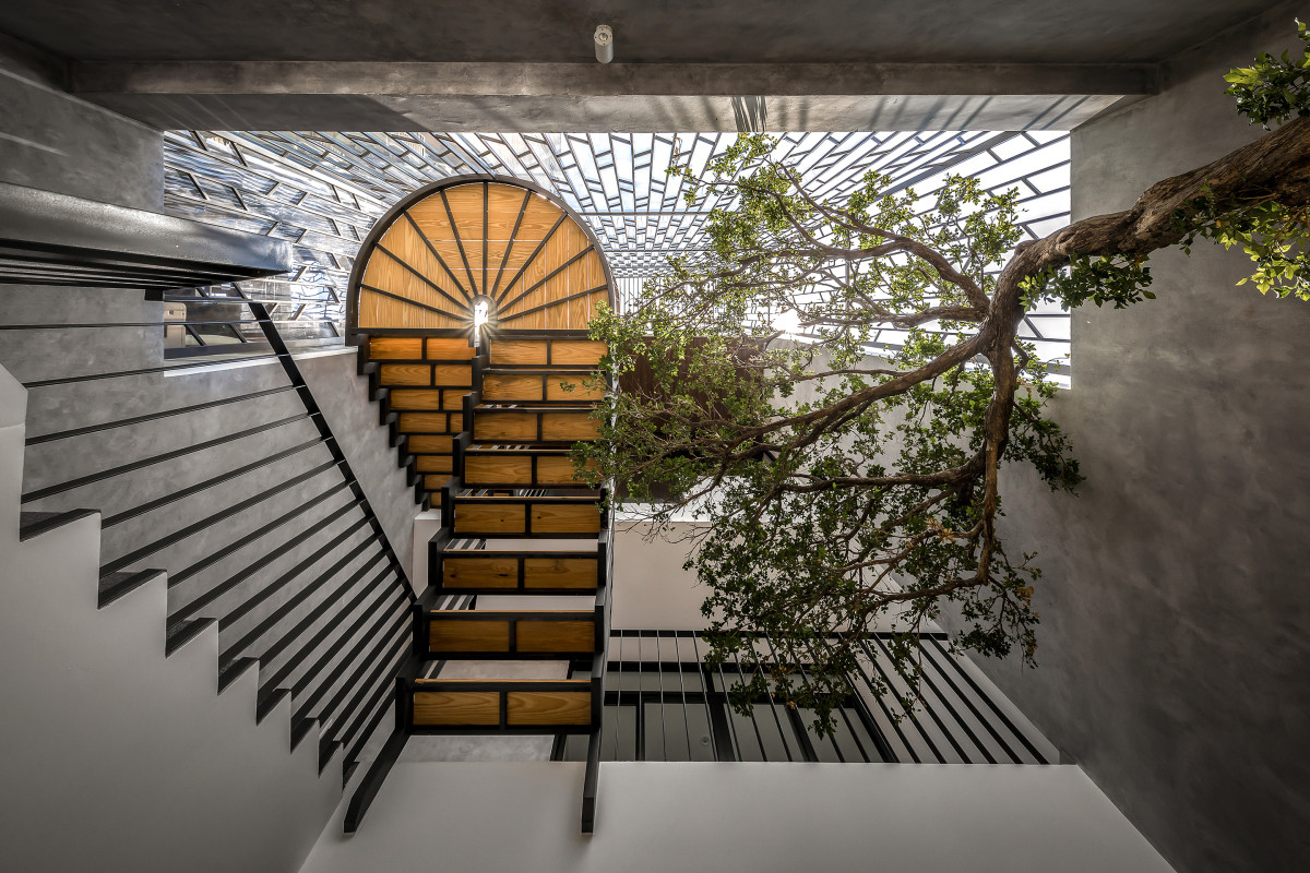 Cầu thang phía sau nhà có hình dáng đa dạng, thêm một phần xoắn ốc kết hợp với giếng trời và cây xanh tạo không gian mở, gần gũi với thiên nhiên.