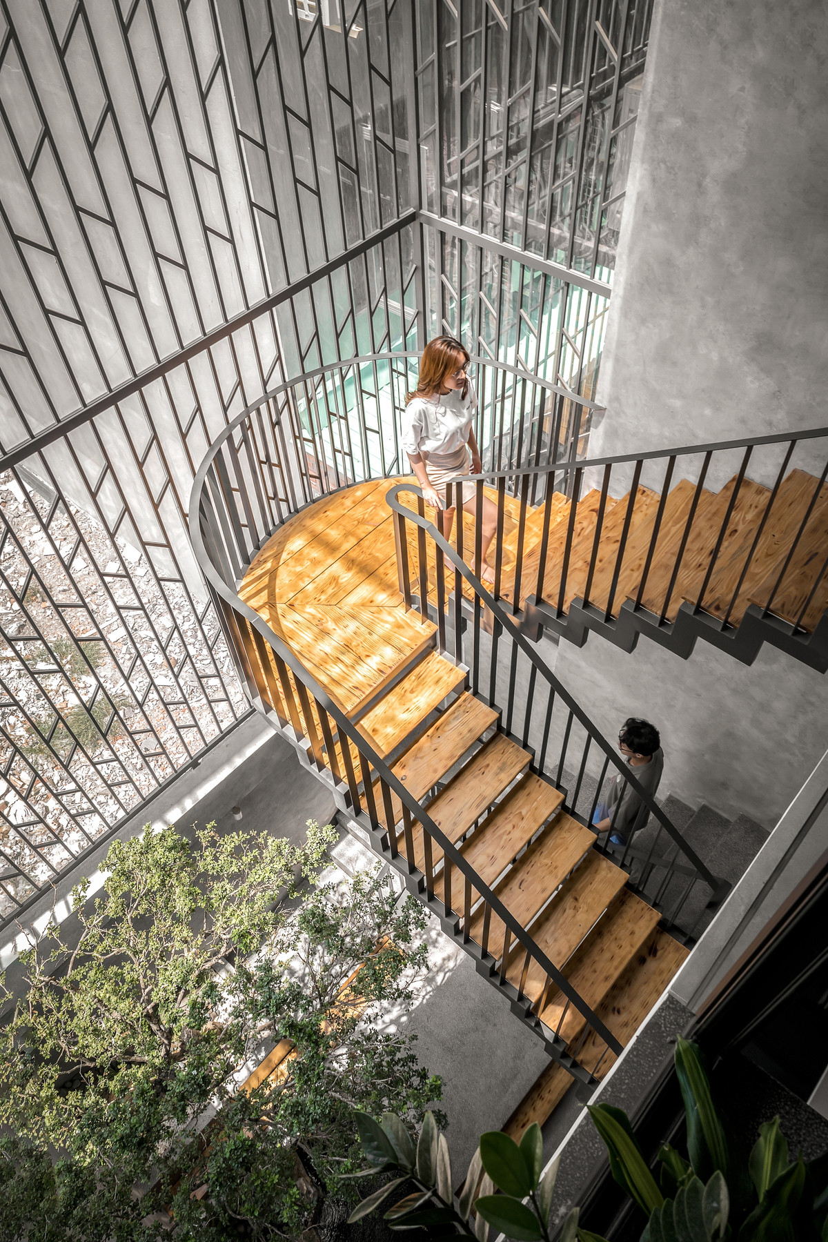 Cầu thang kết hợp với khoảng thông tầng sau nhà tạo ra giếng trời lớn giúp căn nhà lấy sáng từ phía sau.