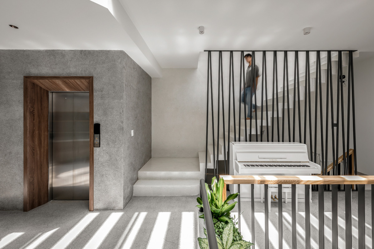 Giếng trời và phần cầu thang chuyển sang vị trí giữa căn nhà để nâng cao tính riêng tư, giúp đón ánh sáng tự nhiên từ mái cho không gian bên trong, đồng thời giảm bớt chiều sâu cho hành lang.