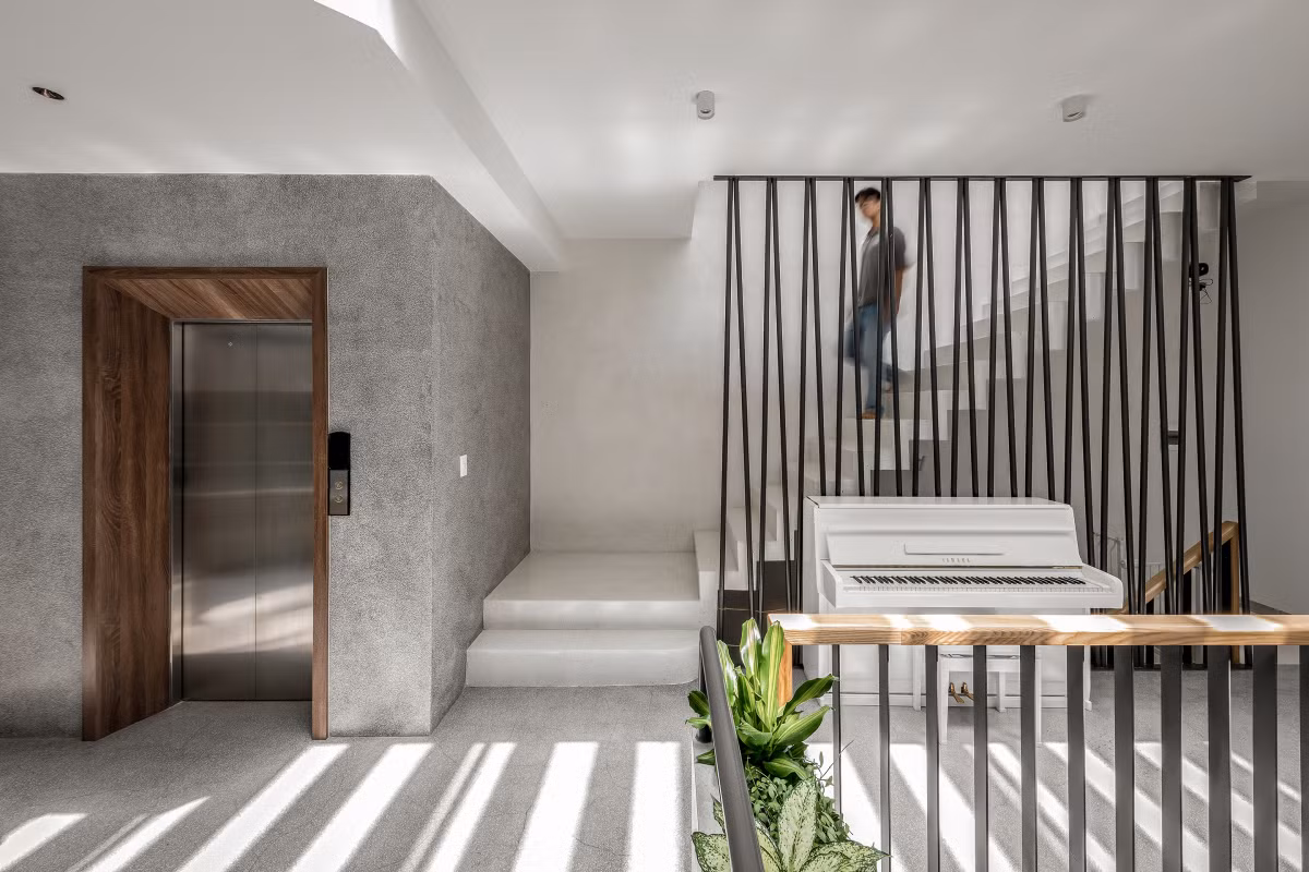 Giếng trời và phần cầu thang chuyển sang vị trí giữa căn nhà để nâng cao tính riêng tư, giúp đón ánh sáng tự nhiên từ mái cho không gian bên trong, đồng thời giảm bớt chiều sâu cho hành lang.