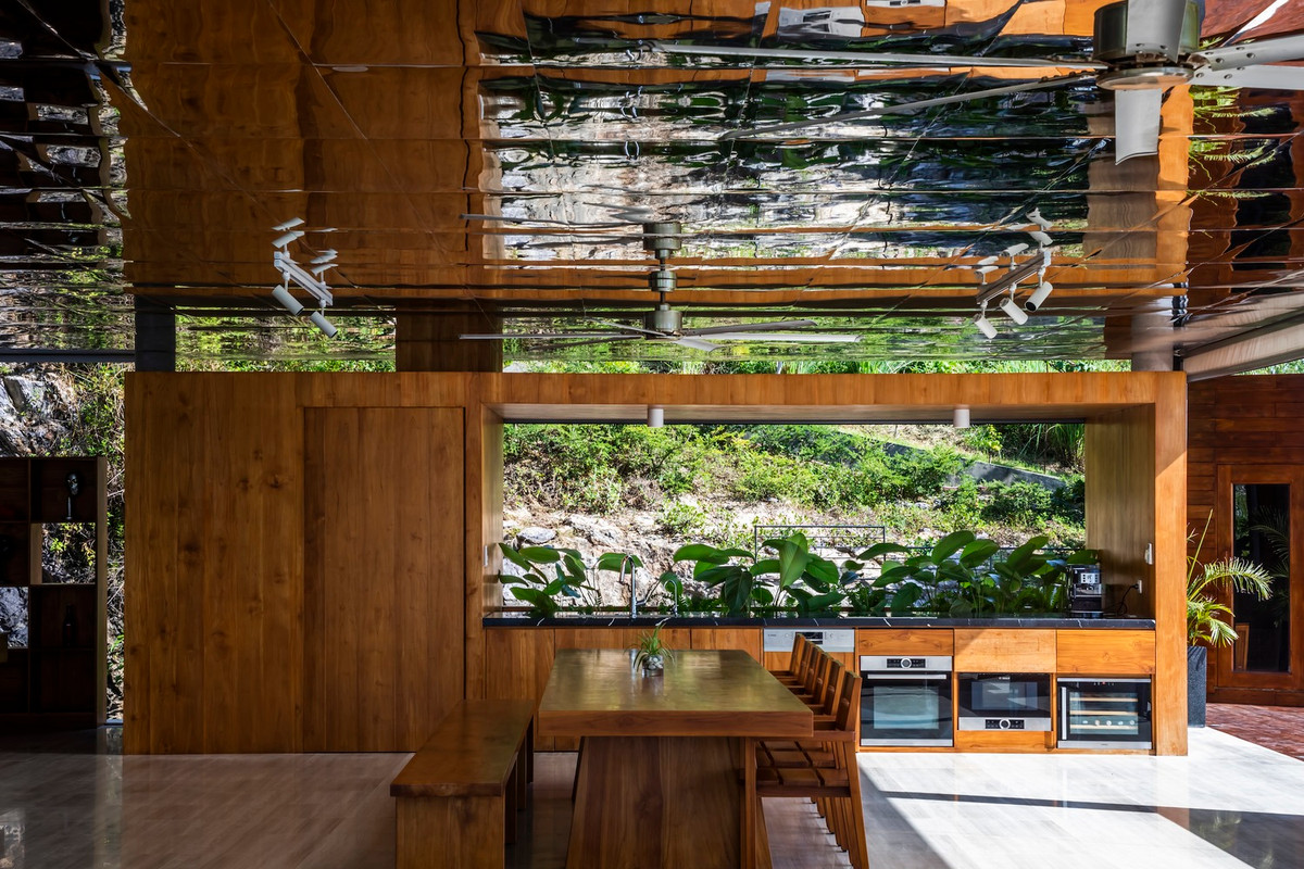 Tầng 1 bao gồm bể bơi, phòng khách chìm, góc giải trí, khu ăn uống và bếp.