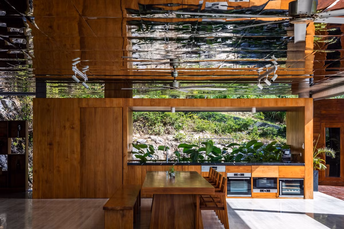 Tầng 1 bao gồm bể bơi, phòng khách chìm, góc giải trí, khu ăn uống và bếp.