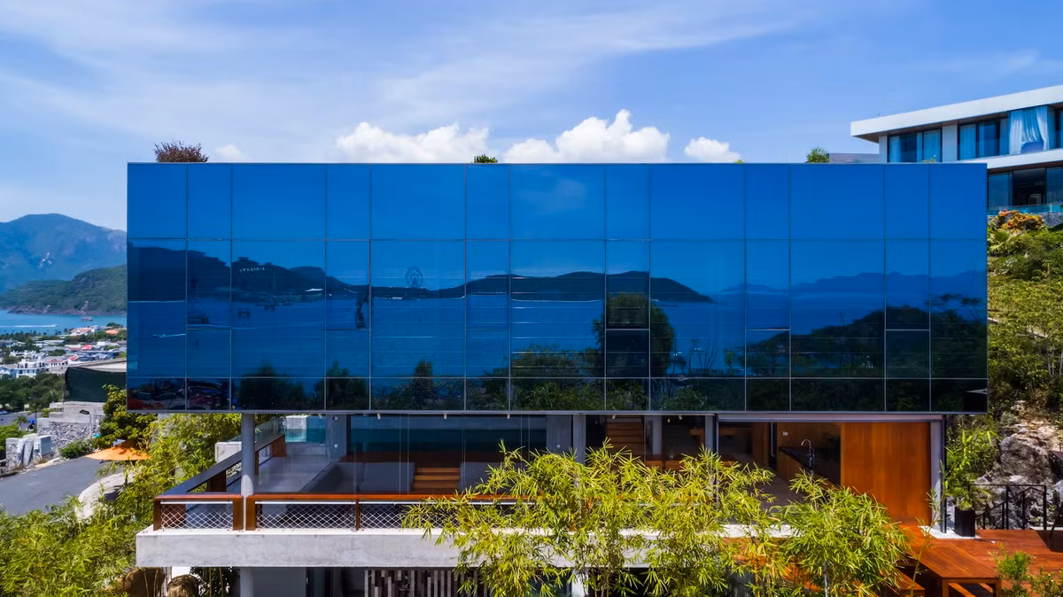 Trần gương với nhiều phản chiếu, mang thảm thực vật và cảnh quan xung quanh vào căn biệt thự.