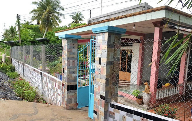 Ông Nguyễn Minh Tấn (ngụ ấp Bình Tịnh B, xã Hòa Tịnh, H.Mang Thít, Vĩnh Long) được nhiều người biết đến với ngôi nhà có phần cổng và tường rào ốp bằng vỏ iPhone. Ảnh: Tiền phong