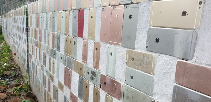 Theo đó, hàng rào dài khoảng 20m, cao trên 1m, cổng chào cao khoảng 2m đều được ốp bằng vỏ điện thoại iPhone. Ảnh: Nlđ