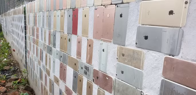 Theo đó, hàng rào dài khoảng 20m, cao trên 1m, cổng chào cao khoảng 2m đều được ốp bằng vỏ điện thoại iPhone. Ảnh: Nlđ
