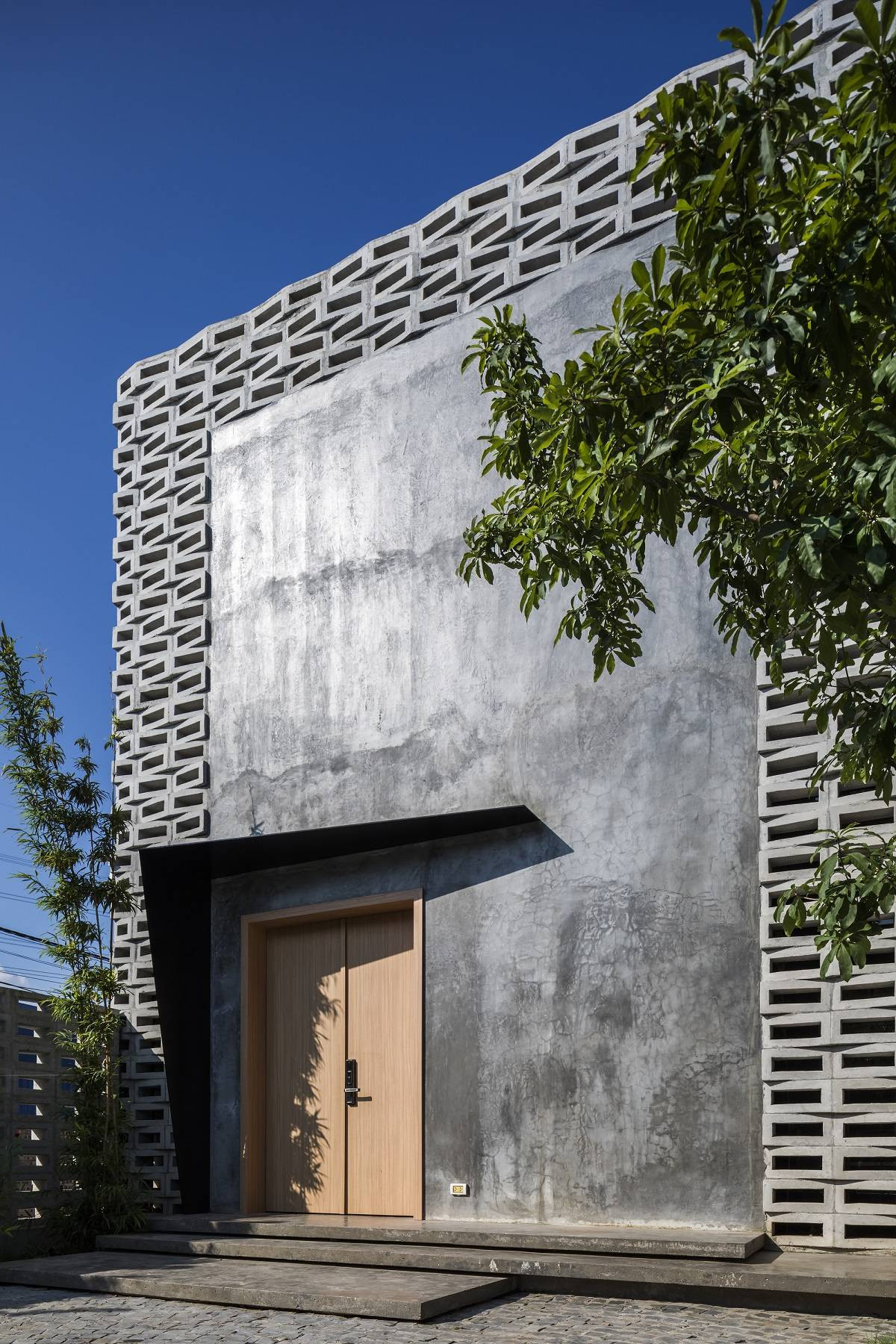 Căn nhà nằm trên mảnh đất có diện tích lý tưởng, chiều rộng 8,6 m và chiều dài 26,8 m. Do tiếp giáp với một con đường nên nếu không được thiết kế cẩn thận, không gian trong nhà sẽ bị ảnh hưởng bởi khói bụi và tiếng ồn từ bên ngoài.