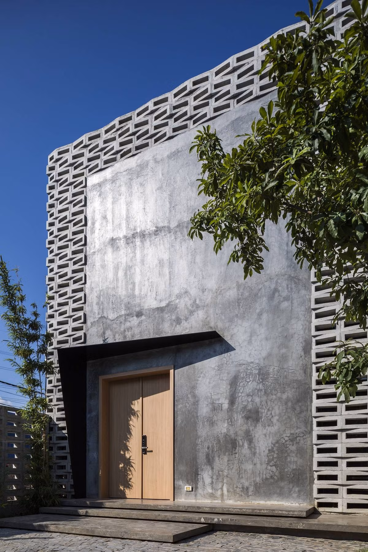 Căn nhà nằm trên mảnh đất có diện tích lý tưởng, chiều rộng 8,6 m và chiều dài 26,8 m. Do tiếp giáp với một con đường nên nếu không được thiết kế cẩn thận, không gian trong nhà sẽ bị ảnh hưởng bởi khói bụi và tiếng ồn từ bên ngoài.