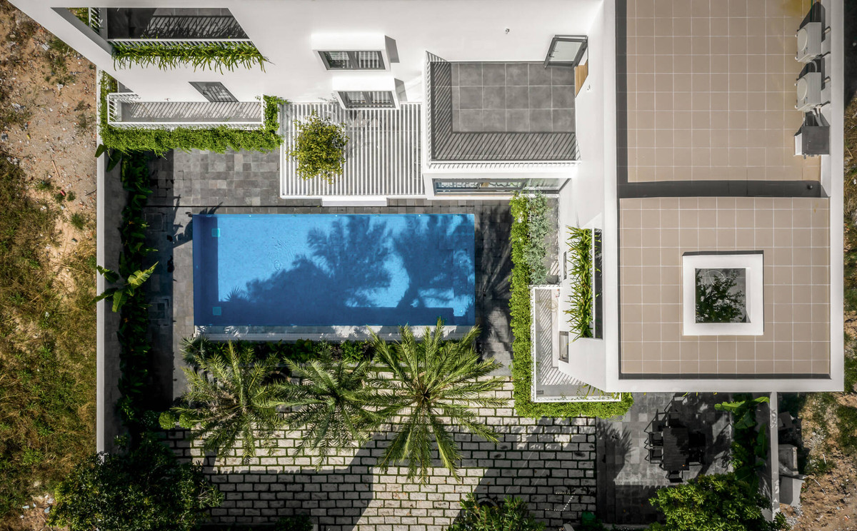 Tổ hợp không gian theo tuyến chữ L ôm trọn hồ bơi và sân vườn phía trước.