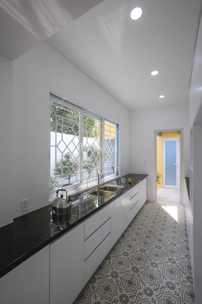 Toàn bộ tường và kệ bếp cũng sử dụng một tông màu trắng khiến căn bếp trông rộng hơn.