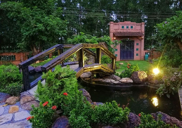 Cổng nhà mang phong cách cổ xưa, hoà hợp với không gian vườn tược xưa cũ. Ảnh: Dân trí