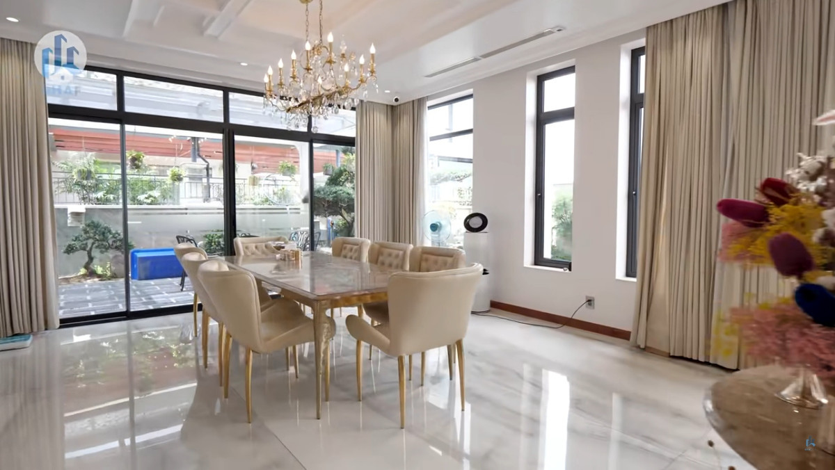 Bàn ăn có mặt bằng đá sang trọng, phía trên trang trí bằng đèn chùm.