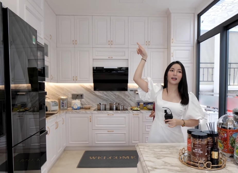 Khu bếp sử dụng gam màu trắng chủ đạo với hệ tủ kịch trần hiện đại.