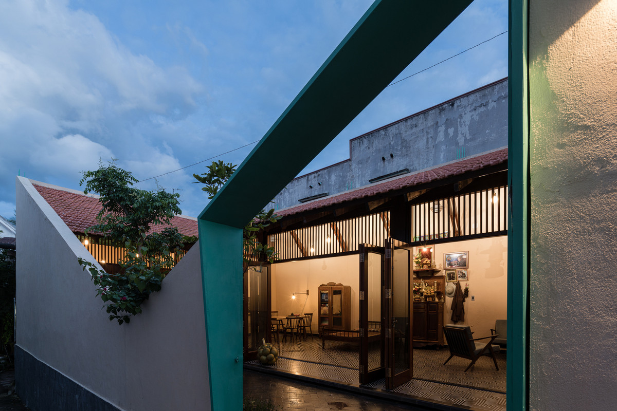 Nhà bố trí cấu trí hình chữ C, các không gian sinh hoạt nằm bao quanh một khoảng sân và bức tường rào xiên theo hệ mái dốc.